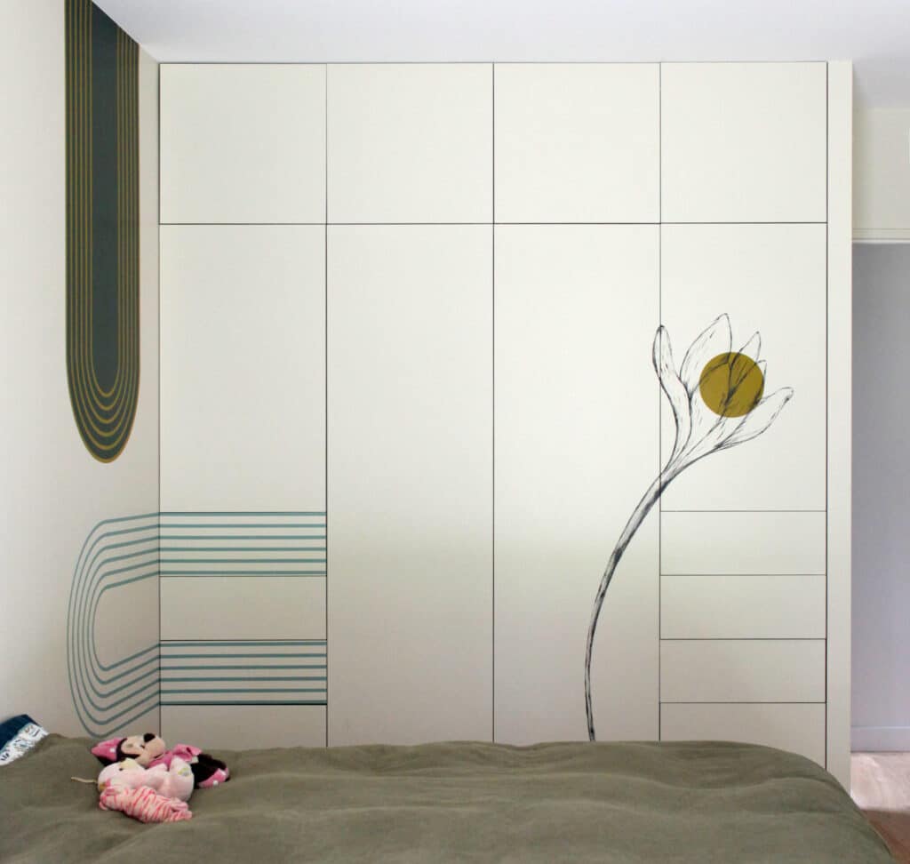 Dressing Sur Mesure avec Motifs Artistiques et Graphiques Dressing sur mesure blanc décoré d'une fleur et d'arches graphiques dans une chambre à la déco minimaliste.